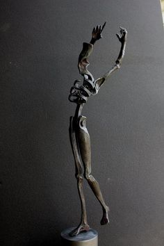 a bronze statue of a person reaching up