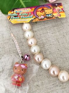 the hello kitty necklace has been placed next to a card and some other items on it