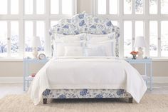 a bed with blue and white flowers on it