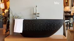 a black bath tub sitting on top of a wooden table