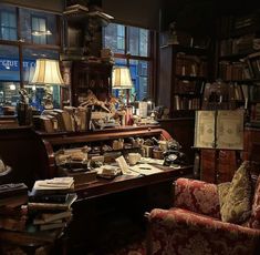 an old fashioned library with many books on the shelves and chairs in front of it