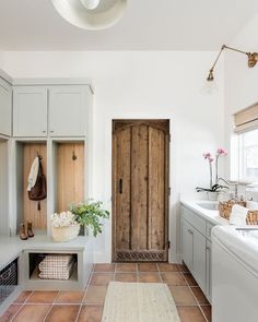 a kitchen with white cabinets and wooden doors