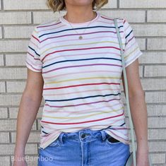 This lightweight rainbow stripe top brings a smile after a rainstorm, or just because! Multicolor Vertical Striped Tops For Spring, Spring Multicolor Vertical Striped Tops, Trendy Rainbow Print Striped Tops, Trendy Striped Rainbow Print Tops, Trendy Striped Tops With Rainbow Print, Multicolor Cotton T-shirt For Day Out, Striped Rainbow Print T-shirt For Spring, Spring Striped T-shirt With Rainbow Print, Multicolor T-shirt For Spring Day Out