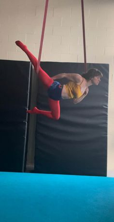 a woman is doing aerial acrobatics on a trampoline