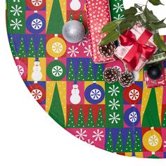 a christmas themed table cloth with presents and decorations on it, including a potted plant