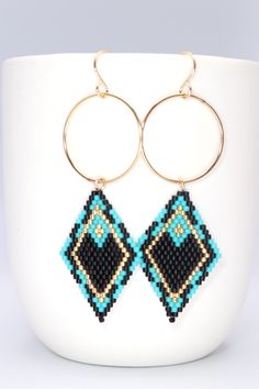 Are you dreaming of a day at music festival or a night out on the town? Accessorize with these boho glam handmade long gold dangle earrings. Fabulous boho chic seed bead earring design featuring 14k gold filled hoops accented with turquoise and black beadwork in a southwestern style. Eye-catching and fun! Size Length 3 inches Width 1 inch Materials Premium Delica Seed Beads Beading Thread 14k Gold Filled Hoops, Ear Wires & Jump Ring Earring Inspired, Seed Bead Earring, Silver Pearl Bracelet, Beaded Jewelry Earrings, Beaded Stuff, Beaded Chandelier Earrings, Hoop Dangle Earrings, Beaded Earrings Native, Bead Earring