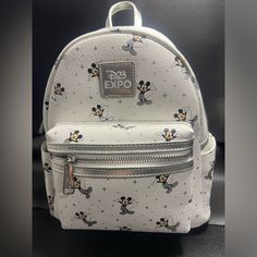 Exclusively Designed For The D23 Expo, This Mini Backpack From Loungefly Features A Beloved Character From The Disney Franchise - Mickey Mouse. The White Color And Contemporary Design Make It A Stylish Addition To Any Disneyana Collection. The Backpack Is Of Size Mini And Was Manufactured In China In 2022. It Has Not Been Modified And Is An Authentic Loungefly Product. Perfect For Collectors Or Fans Of The Iconic Character, This Backpack Is A Must-Have For Any Disney Enthusiast. Loungefly Mickey, Mickey Mouse Loungefly Backpack, Cute Mickey Mouse Standard Backpack, Mickey Mouse Standard Backpack, Mickey Backpack, Mickey Mouse Bag, Loungefly Bag, Mini Backpack, Iconic Characters