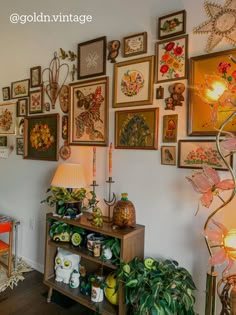 a room filled with lots of framed pictures on the wall next to a wooden table