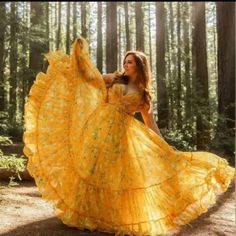 a woman wearing a yellow dress in the woods