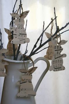 a white pitcher filled with lots of paper cut out to look like music notes hanging from branches