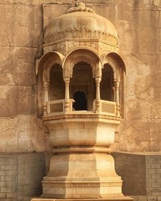 an old stone structure with a bell on top