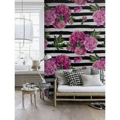 a living room with pink flowers on the wall and black and white striped wallpaper