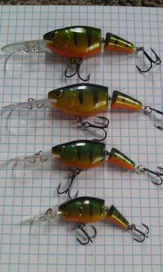 five fishing lures lined up on a sheet of paper