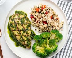 a white plate topped with broccoli and rice next to a side of meat