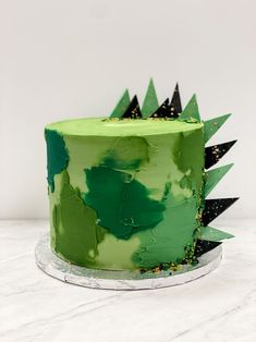 a cake with green frosting and black sprinkles