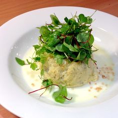 a white plate topped with food and veggies on top of a wooden table