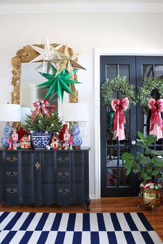 a black dresser with christmas decorations and wreaths on it