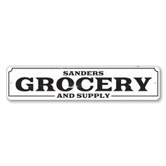 a white and black sign that says grocery and supply on the front, with an arrow pointing to it