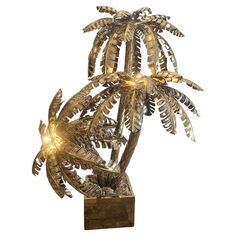 a metal palm tree with lights on it's branches and leaves in the center