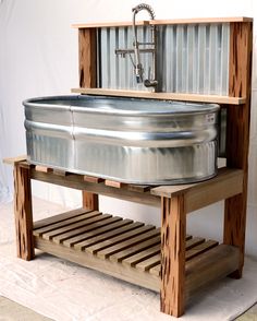 a large metal tub sitting on top of a wooden stand