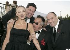 two men and a woman are posing for a photo with one man in a tuxedo