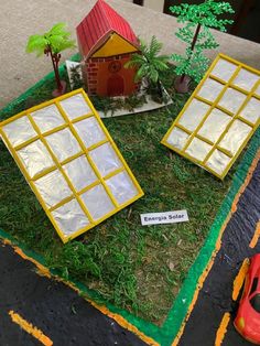 two fake windows sitting on top of a grass covered field next to a toy car