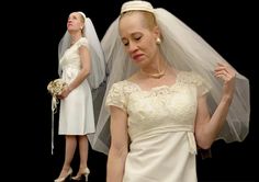 two women in white dresses and veils standing next to each other