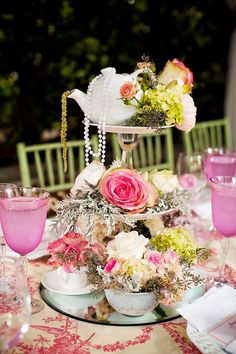 a table topped with pink and white flowers next to plates filled with food on top of a table