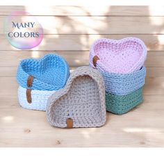 three crocheted baskets sitting on top of a wooden table