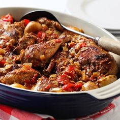 a casserole dish with meat and vegetables in it on a red and white napkin