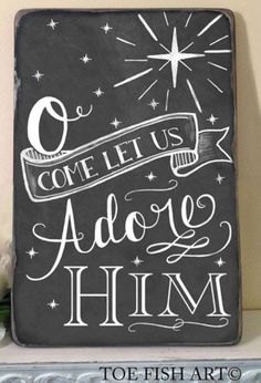 a chalkboard sign that says come let us adore him with stars on it