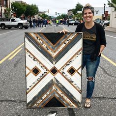 a woman standing next to a large piece of art on the side of a road