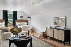 a living room filled with furniture next to a window covered in green curtains and white walls