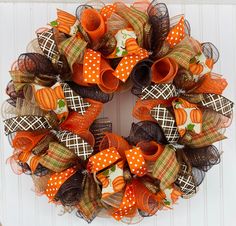 an orange and brown mesh wreath with pumpkins