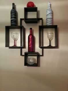 three black shelves with wine glasses and bottles on them