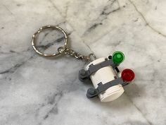 a lego keychain that is on top of a marble counter with a light bulb