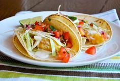 two fish tacos on a white plate