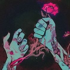 two hands are holding flowers in the air