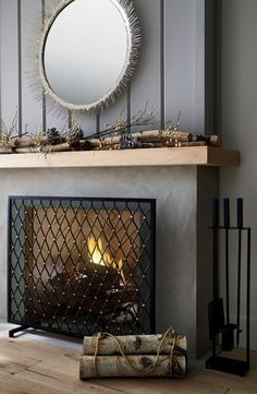 a fire place with a mirror above it