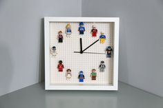 a clock made out of legos sitting on top of a shelf next to a wall