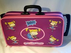 a pink and purple suitcase with cartoon characters on the front, black handles and handle