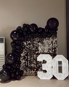 the number 30 is surrounded by balloons and streamers in front of a wall with sequins