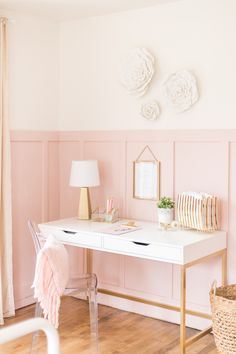 a white desk sitting in front of a pink wall