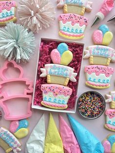 decorated birthday cookies in a box on a table