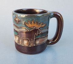 a brown and blue coffee mug with an image of a moose on the inside of it