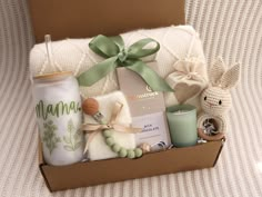 a baby gift box filled with items such as a bottle, candle and stuffed animals