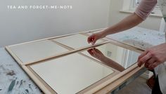 a person is placing mirrors on top of a table in the process of being assembled