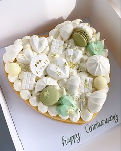 a heart shaped cookie decorated with white and green candies on top of a card