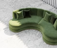 a green curved couch sitting on top of a marble floor