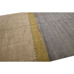 an area rug with different colors and patterns on the carpet, including yellows, greys, and browns